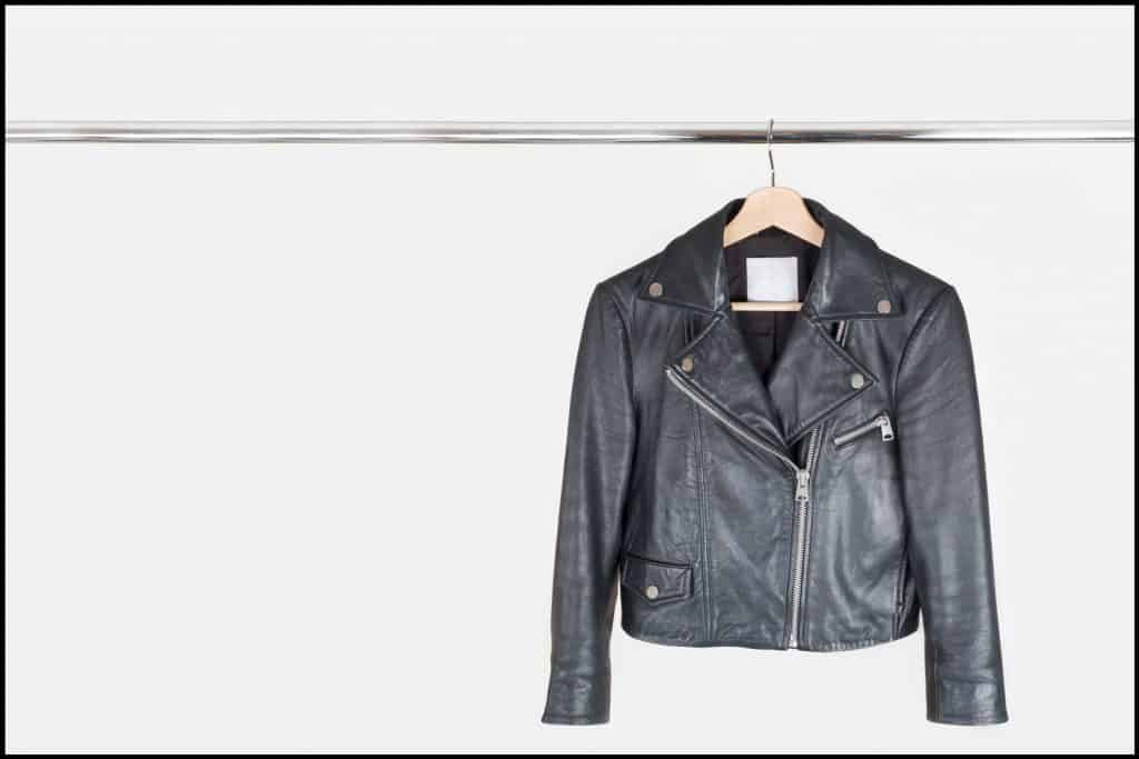 Hanging a men Classic moto leather jacket into a wooden hanger